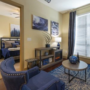 Apartments in Uptown Houston, Galleria Area A cozy living room with blue furniture and a fireplace, perfect for apartments in the Galleria Area or Uptown Houston.