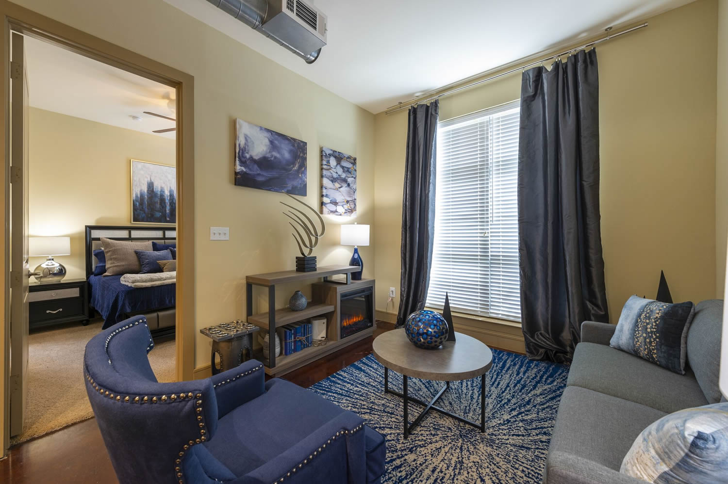 Apartments in Uptown Houston, Galleria Area An inviting living room with a stylish blue couch and a soft blue rug. Perfect for apartments in Uptown Houston or the Galleria Area.