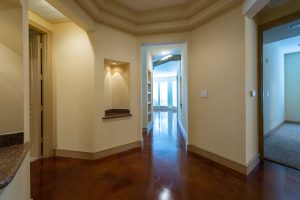 Apartments in Uptown Houston, Galleria Area A hallway with polished wooden floors, cream-colored walls, and multiple doorways leading to different rooms in a cozy three-bedroom apartment. The Augusta Apartments In The Galleria Area of Houston 2660 Augusta Drive Houston, TX 77057 p: (832) 648-3088 f: (832) 675-0401